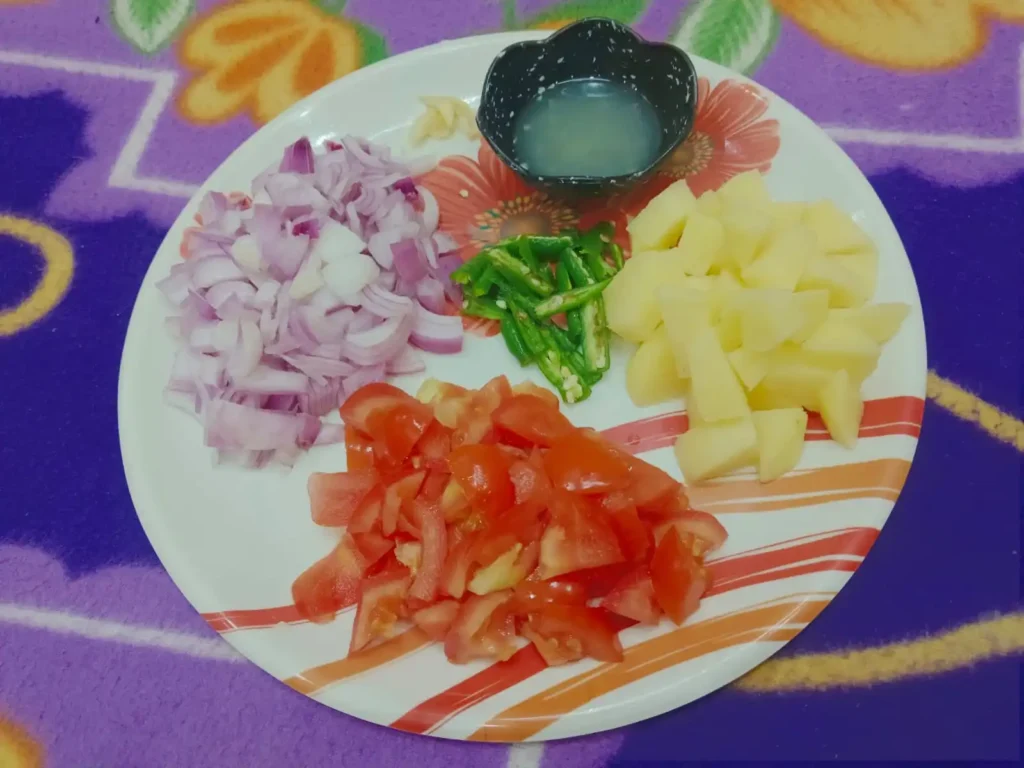 First, finely chop the onion, tomato, potato, green chilli, and garlic, and extract the lemon juice.