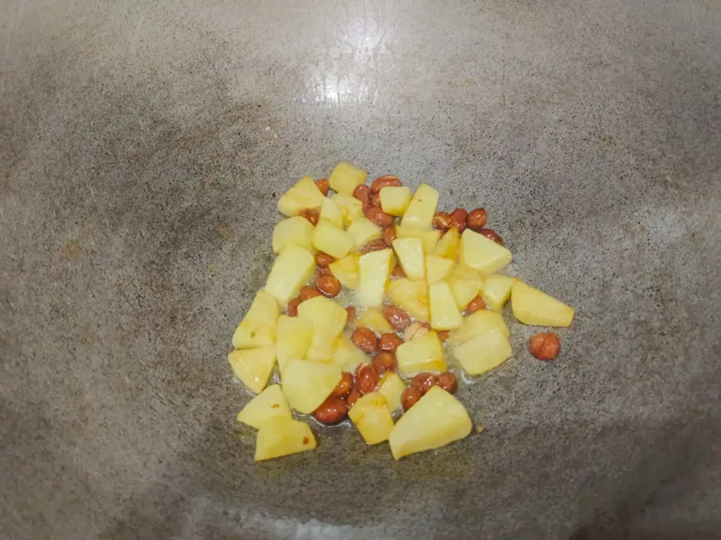 In a pan, heat 1 tsp. of oil, add the peanuts & chopped potatos, and toast until crunchy. You can set aside the peanuts to add crunch and flavour to your dish later.