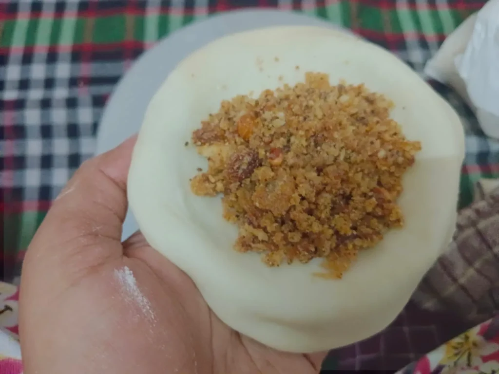 2. Place 1-2 tablespoons of filling in the centre of the ball and fold it into a half moon. Be sure to seal the edges tightly.